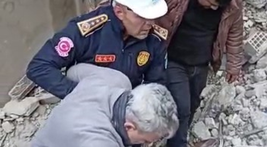 Enkazdan çıkardığı yaşlı adama kendi botlarını giydirdi