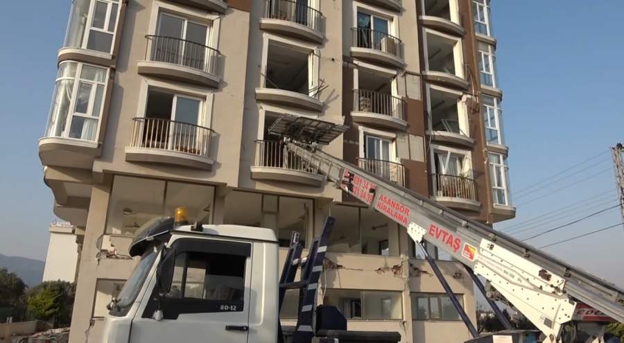 Hatay'da hasarlı binalardan eşya taşıdılar