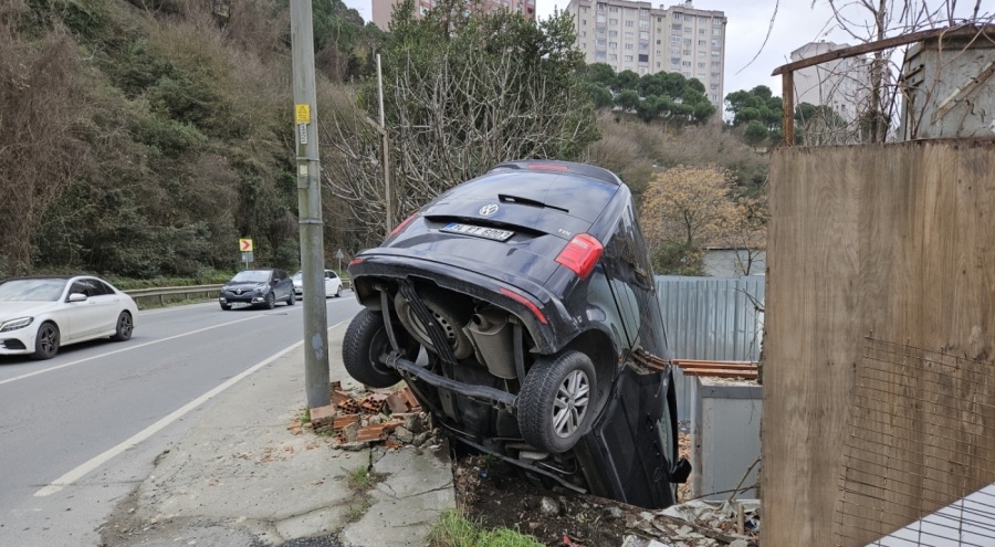Yoldan çıkan araç inşaat alanının duvarında asılı kaldı