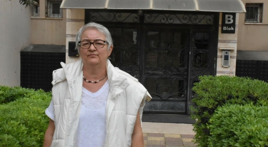 Sandalyeyle darbedilen site sakini, penceresine pankart astı