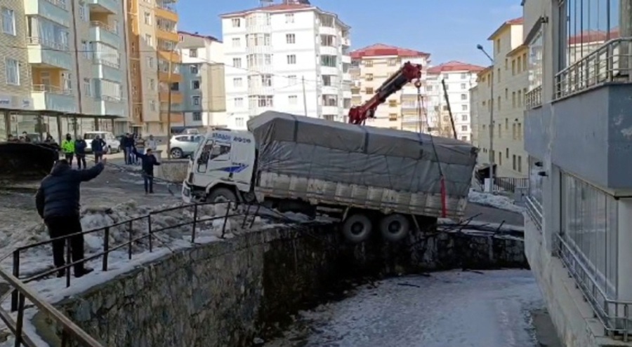 Buzda kayan kamyon, duvarda asılı kaldı