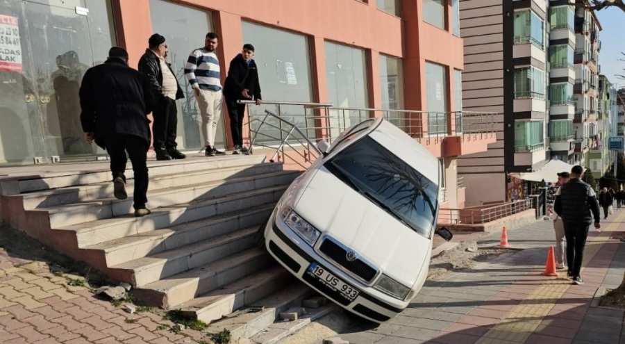 Park halindeki araba kayarak binanın merdivenlerinde asılı kaldı