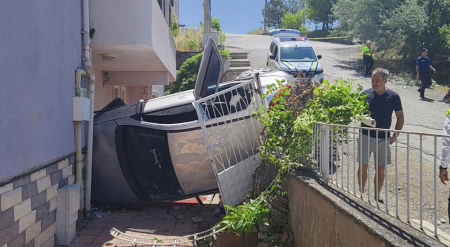 Rampa aşağı kayıp ağaca çarpan otomobil apartman girişinde devrildi!