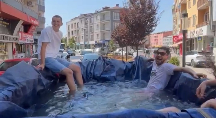 Bursa'da sıcaktan bunalan vatandaşlar traktörün römorkunu havuz yapıp şehir turu attılar