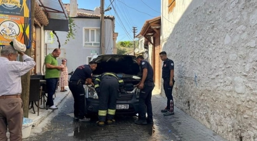 Park halindeki araba yandı, mahalleli hortumla koştu