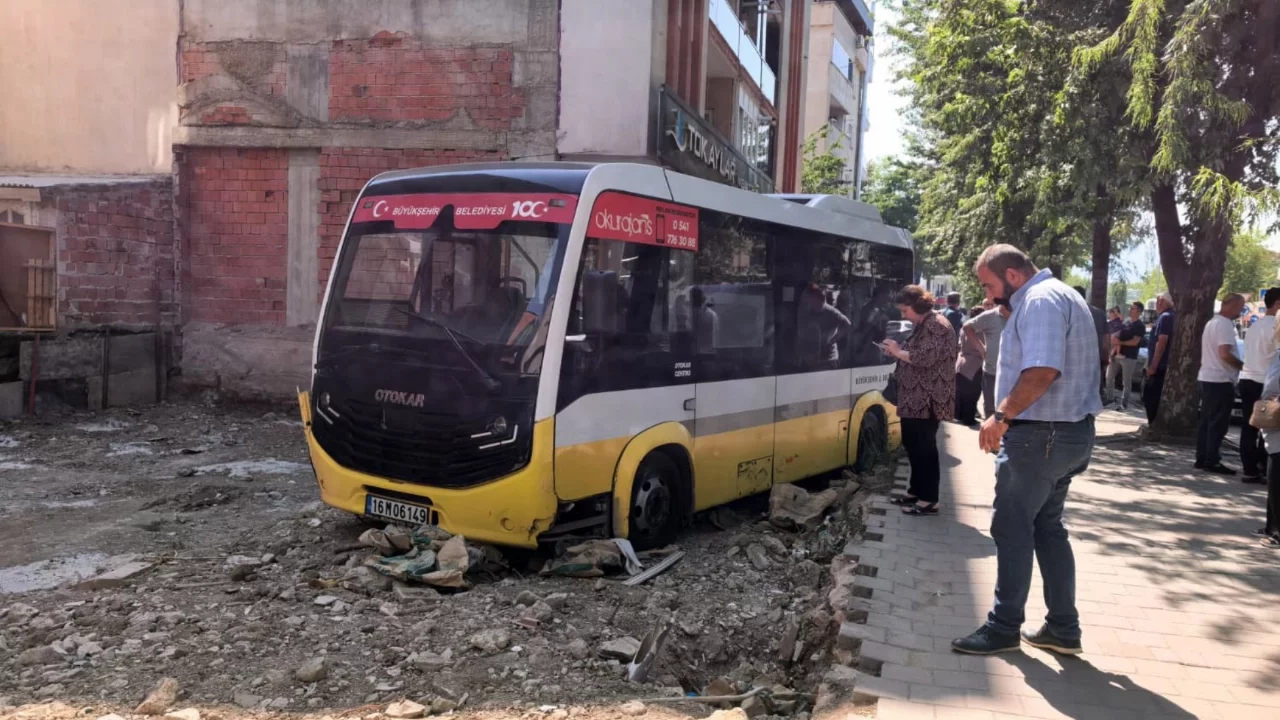 Bursa'da özel halk minibüsü, iş yerine çarptıktan sonra boş arsaya uçtu