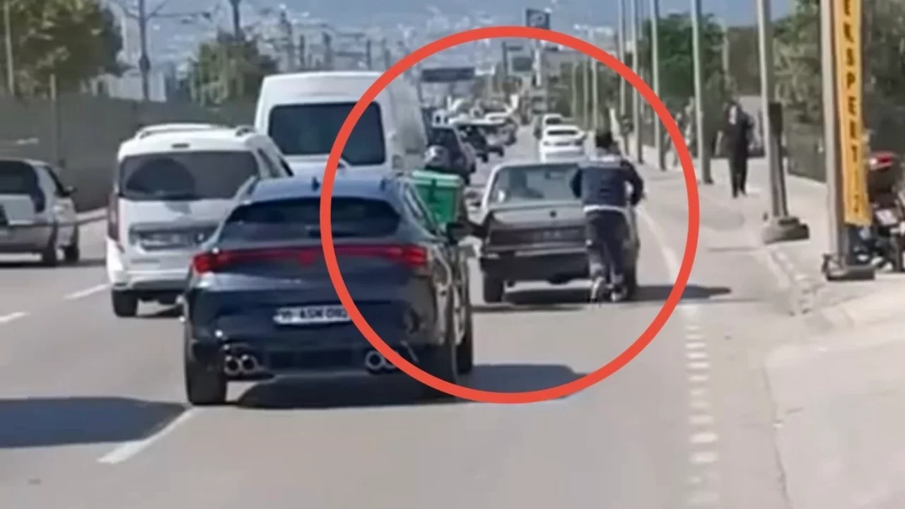 Bursa'da motokurye motosikletinden ayağını uzatıp otomobili itti