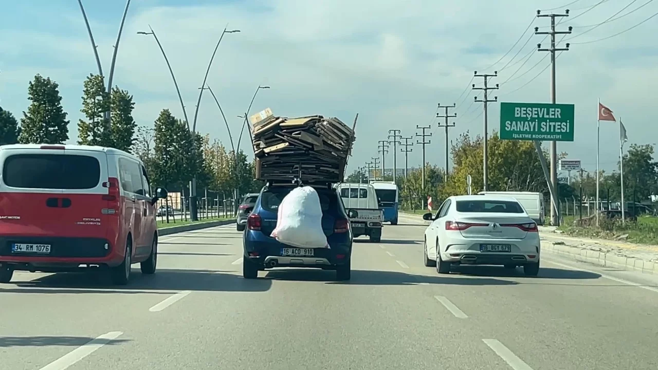 Bursa'da tehlikeli taşımacılık! Otomobilin üzerine yüklediği kartonlarla trafikte ilerledi